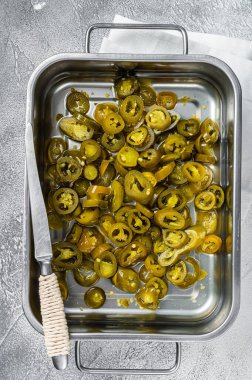 Çelik tepside yeşil dilimlenmiş organik turşu. Beyaz arka plan. Üst görünüm