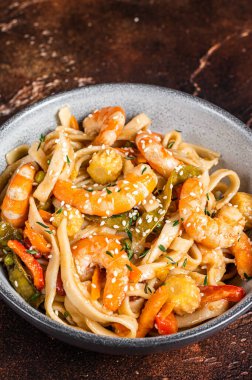 Çin tavasında karides karidesli udon usulü deniz mahsulü erişte. Siyah arka plan. Üst görünüm