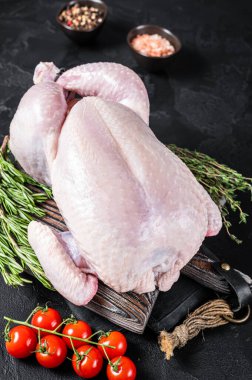 Tahta tahtada kekik ve biberiyeyle pişirilmemiş çiğ tavuk. Siyah arka plan. Üst görünüm