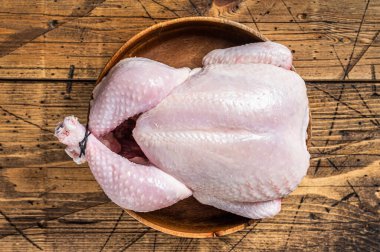 Çiğ tavuk, ahşap tabakta kümes hayvanları. Ahşap arka plan. Üst görünüm