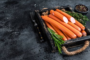 Tahta tepside otlu Frankfurter sosisleri. Siyah arka plan. Üst Manzara. Boşluğu kopyala