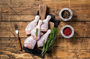 Taze tavuk budu derili bacaklar, çiğ tavuk eti. Ahşap arka plan. Üst görünüm