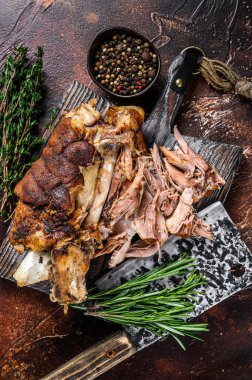 Kızartılmış ve et satırıyla ahşap bir tahtanın üzerinde Alman domuz budu Eisbein eti. Karanlık arka plan. Üst görünüm