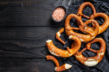 Alman yapımı tuzlu krakerler ahşap bir kırsal masada. Siyah ahşap arka plan. Üst Manzara. Boşluğu kopyala
