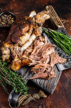 Kızartılmış ve et satırıyla ahşap bir tahtanın üzerinde Alman domuz budu Eisbein eti. Karanlık arka plan. Üst görünüm