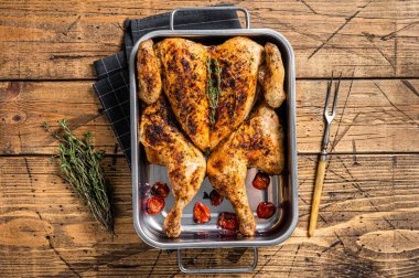 Ev yapımı tavuk rostosu, kekik ve fırın tabağı. Ahşap arka plan. Üst görünüm