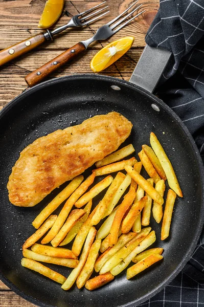 Engelska Traditionell fisk och chips skålen i en panna. Trä bakgrund. Ovanifrån — Stockfoto