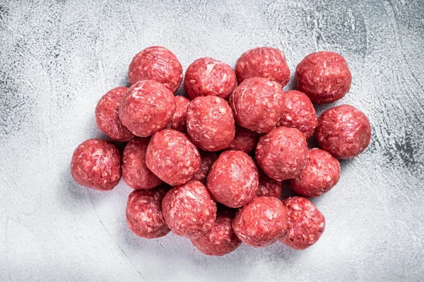 Pişmemiş çiğ biftek ve mutfak masasında baharatlı domuz köftesi. Beyaz arka plan. Üst görünüm