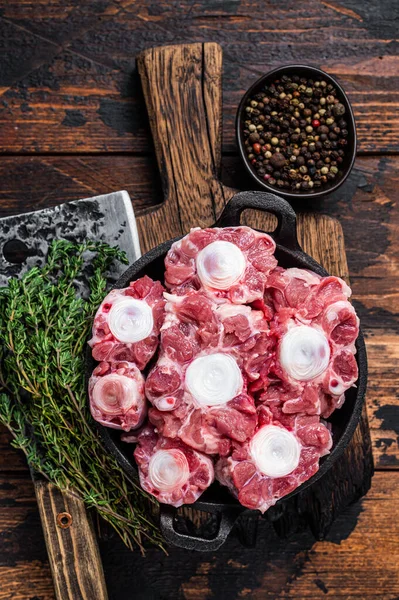 Carne bovina cruda Oxtail Carne su tavola di legno macellaio con mannaia. Fondo in legno scuro. Vista dall'alto — Foto Stock