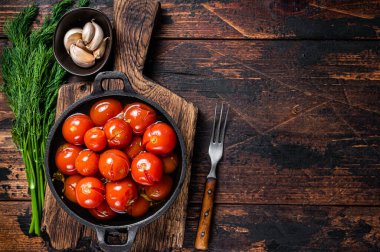 Tuzlu vişneli domates turşusu, içinde otlar ve dereotlar var. Koyu ahşap arka plan. Üst Manzara. Boşluğu kopyala