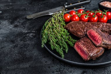 Kızarmış Denver bifteği ve kekik tabağı. Siyah arka plan. Üst Manzara. Boşluğu kopyala