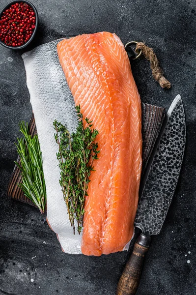 Pesce filetto di salmone crudo fresco sul tagliere con coltello. Fondo nero. Vista dall'alto — Foto Stock