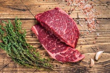 Çiğ Denver ya da kasap masasında üzerinde otlar olan en iyi bıçaklı biftek. Ahşap arka plan. Üst görünüm