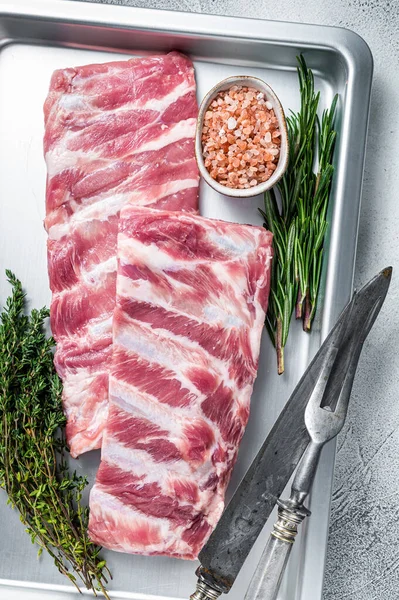 Rek van Rauwe varkensvlees spareribs in keuken oven lade met kruiden. Witte achtergrond. Bovenaanzicht — Stockfoto