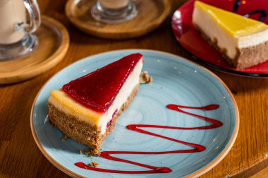 Klasik New York çileği ve limonlu cheesecake, kafede ahşap bir masada. Üst görünüm