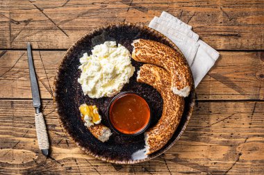 Geleneksel Türk kahvaltısı - kayak pıhtılaşmış krema, simit simit ve bal. Ahşap arka plan. Üst görünüm