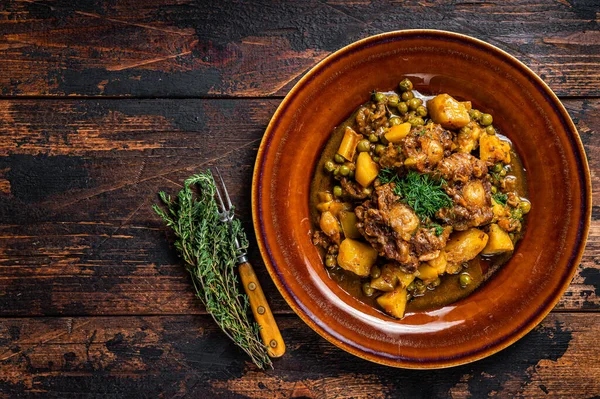 Cosce di vitello di manzo stufato con verdure in un piatto rustico. Fondo in legno scuro. Vista dall'alto. Copia spazio — Foto Stock