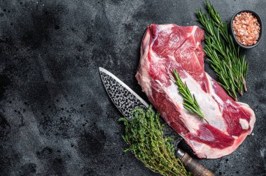 Taze çiğ kuzu eti ya da kasap bıçağıyla keçi omzu eti. Siyah arka plan. Üst Manzara. Boşluğu kopyala