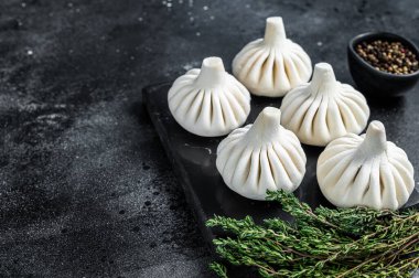 Khinkali usulü çiğ hamur köftesi, biftek ve kuzu eti. Siyah arka plan. Üst Manzara. Boşluğu kopyala