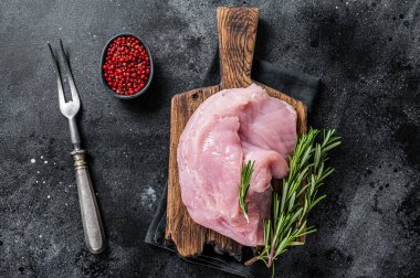 Taze çiğ büyük hindi göğsü filetosu tahtada. Siyah arka plan. Üst Görünüm