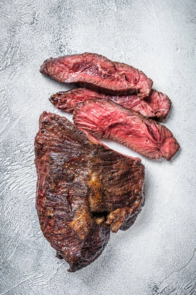 Pečený věšák nebo Onglet nakrájeli hovězí steak na stůl. Bílé pozadí. Pohled nahoru — Stock fotografie