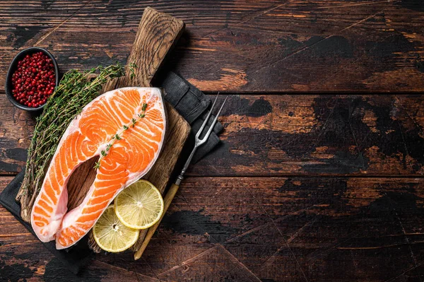 新鮮な生鮭マス魚タイムとレモンと木製のボード上にステーキ.木製の背景。最上階だ。スペースのコピー — ストック写真