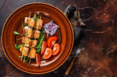 Kır tabağında sebzeli ızgara somon kebabı şiş. Karanlık arka plan. Üst Manzara. Boşluğu kopyala