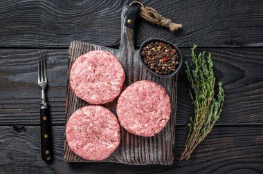 Çiğ tavuklu hindi köftesi, kıymalı pirzola. Siyah ahşap arka plan. Üst görünüm