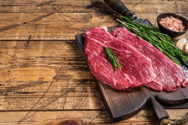 Çiğ biftek ya da tahta tahtada kasap bıçağıyla Picanha bifteği. Ahşap arka plan. Üst Manzara. Boşluğu kopyala