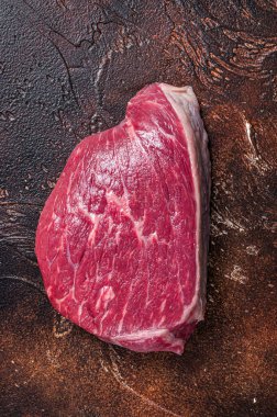 Çiğ biftek dilimi ya da kasap masasında sığır filetosu bifteği. Karanlık arka plan. Üst görünüm
