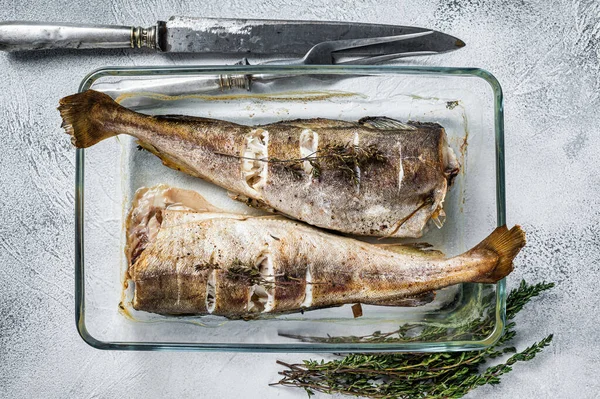 Fiskrätt - rostad torskfisk med örter i bakform. Vit bakgrund. Ovanifrån — Stockfoto