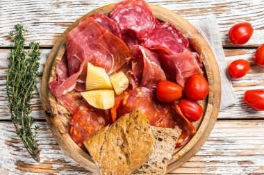 Soğuk et tabağı, ahşap bir tahtanın üzerinde geleneksel İspanyol mezeleri. Beyaz ahşap arka plan. Üst görünüm