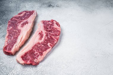 Striploin bifteği ya da New York bifteği, çiğ et kesimi. Beyaz arka plan. Üst Manzara. Boşluğu kopyala