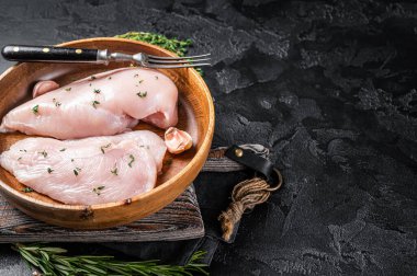 Dilimlenmiş çiğ tavuk göğsü fileto, tavuklu biftekler tabakta. Siyah arka plan. Üst Manzara. Boşluğu kopyala