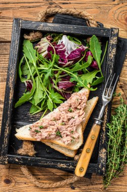 Peynirli ton balıklı sandviç, marul ve roka. Ahşap arka plan. Üst görünüm