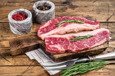 Prime Black Angus bifteği, Raw Striploin veya New York. Ahşap arka plan. Üst görünüm