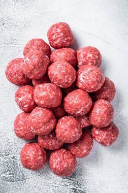 Pişmemiş çiğ biftek ve mutfak masasında baharatlı domuz köftesi. Beyaz arka plan. Üst görünüm