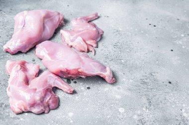 Kasap tahtasında çiğ tavşan bacağı dilimler. Gri arka plan. Üst Manzara. Boşluğu kopyala