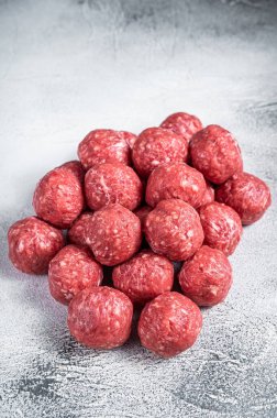 Pişmemiş çiğ biftek ve mutfak masasında baharatlı domuz köftesi. Beyaz arka plan. Üst görünüm