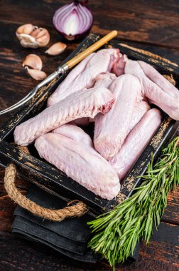 Taze çiğ ördek ve tepside tavuk kanadı. Koyu ahşap arka plan. Üst görünüm