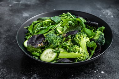 Ispanak, roka yaprağı, pazı ve sebzeli kuzu marulu taze salata karışımı. Siyah arka plan. Üst görünüm