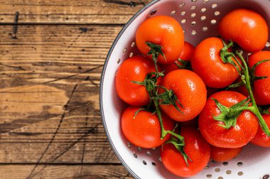 Kevgir soslu kırmızı kiraz domatesleri. Ahşap arka plan. Üst Manzara. Boşluğu kopyala