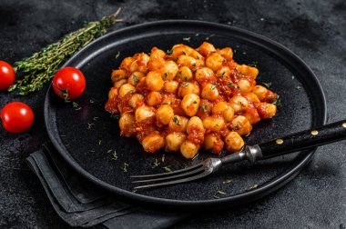 Domates soslu İtalyan Gnocchi patatesli makarna. Siyah arka plan. Üst görünüm