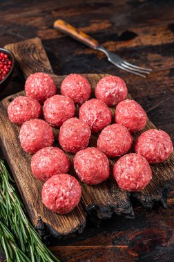 Biberiyeli kıyma ve domuz etinden pişmemiş çiğ köfte. Karanlık ahşap arka plan. Üst görünüm