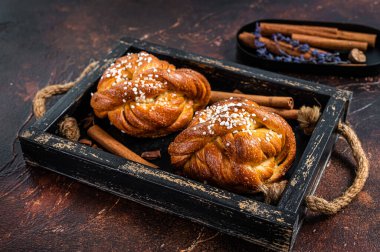 Tarçınlı çörek ya da rulo, İsveç Kanelbullar. Karanlık arka plan. Üst görünüm