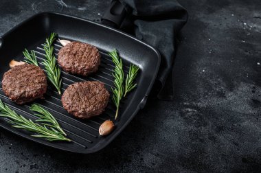 Izgara burgerli köfte ve ızgara tavada baharat. Siyah arka plan. Üst Manzara. Boşluğu kopyala