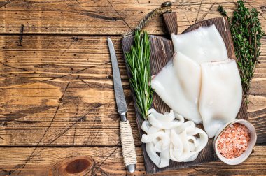 Biberiyeli tahta bir tahtada dilimlenmiş halkalar Raw Calamari veya Squid. Ahşap arka plan. Üst Manzara. Boşluğu kopyala