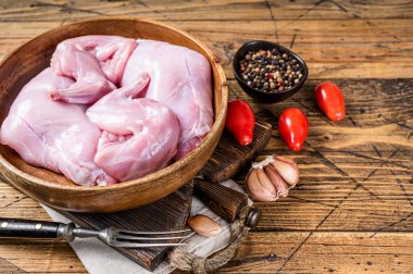 Tavşan bacağı ahşap bir tabakta pişmemiş. Ahşap arka plan. Üst Manzara. Boşluğu kopyala