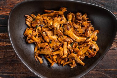 Kızarmış orman mantarı ve şifalı otlar. Ahşap arka plan. Üst görünüm