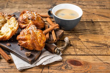 Tarçınlı çöreklerle kahvaltı, İsveç Kanelbulları. Ahşap arka plan. Üst Manzara. Boşluğu kopyala